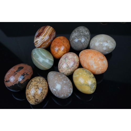 358 - A collection of eleven polished carved agate eggs together with a selection of Avery brass weights.