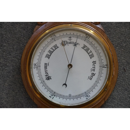 437 - A 20th century oak cased Barometer with carved and scalloped neck.