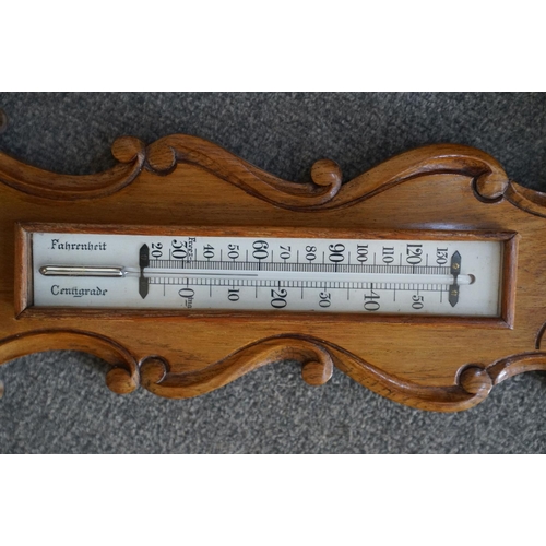 437 - A 20th century oak cased Barometer with carved and scalloped neck.