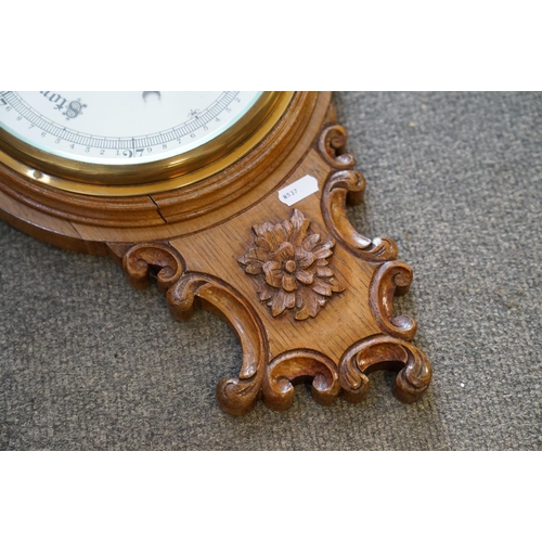 437 - A 20th century oak cased Barometer with carved and scalloped neck.