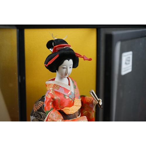 459 - A contemporary figure of a Geisha in a glass cabinet.