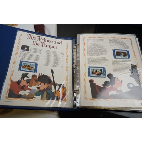 503 - A collection of Classic Disney Movies collector panels and stamps contained within two albums togeth... 