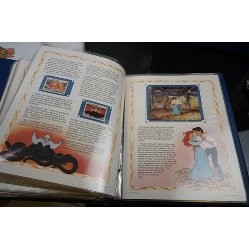 503 - A collection of Classic Disney Movies collector panels and stamps contained within two albums togeth... 