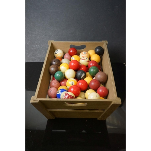 527 - A quantity of pool and snooker balls in a wooden crate.