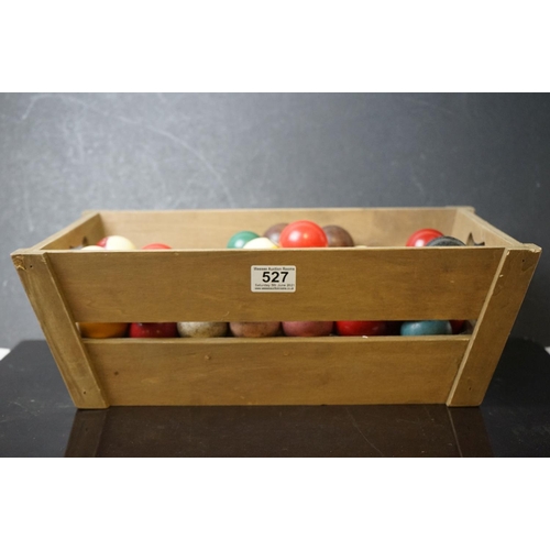 527 - A quantity of pool and snooker balls in a wooden crate.