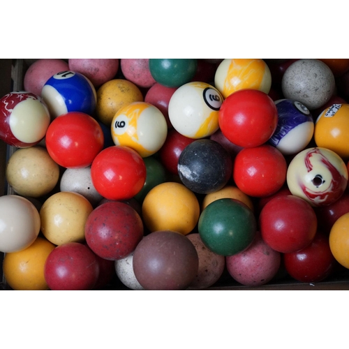 527 - A quantity of pool and snooker balls in a wooden crate.