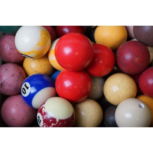 527 - A quantity of pool and snooker balls in a wooden crate.