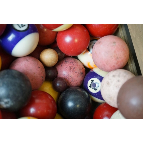 527 - A quantity of pool and snooker balls in a wooden crate.