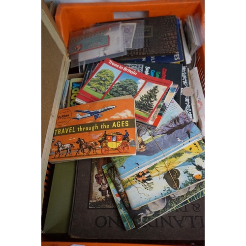 564 - A large collection of mixed ephemera contained within two boxes to include comics, postcards and tea... 