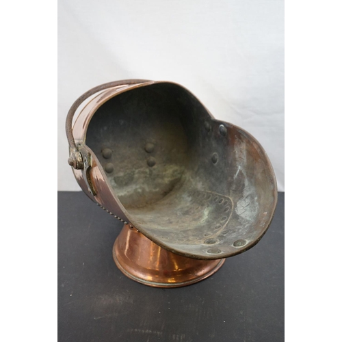 570 - A large copper coal scuttle with old riveted repair.