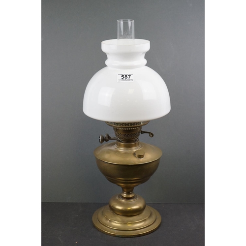 587 - A brass oil lamp with white glass shade.