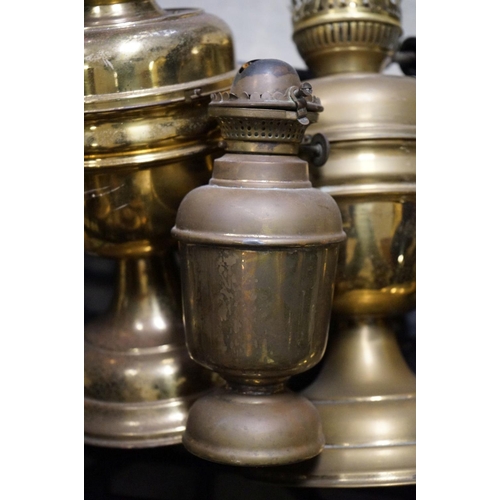 591 - A collection of nine copper and brass oil and gas lamps.