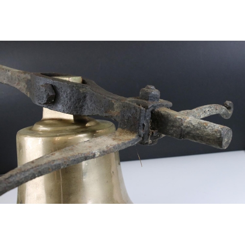 151 - Large Antique Bronze / Bell Metal Bell with Clanger and held on a cast iron bracket, bell 30cms high