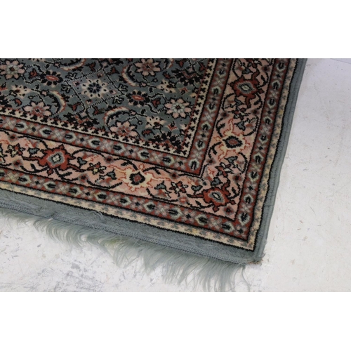 823 - Green and Cream Ground Rug with floral pattern, approx. 171cms x 121cms