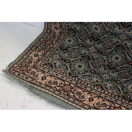 823 - Green and Cream Ground Rug with floral pattern, approx. 171cms x 121cms