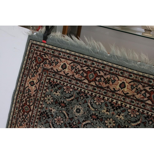 823 - Green and Cream Ground Rug with floral pattern, approx. 171cms x 121cms