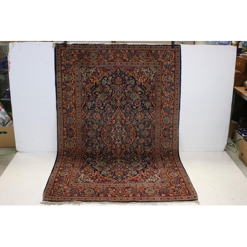 831 - Red and Blue Ground Rug with stylised floral pattern, approx. 202cms x 135cms