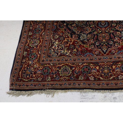 831 - Red and Blue Ground Rug with stylised floral pattern, approx. 202cms x 135cms