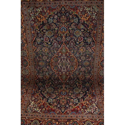 831 - Red and Blue Ground Rug with stylised floral pattern, approx. 202cms x 135cms