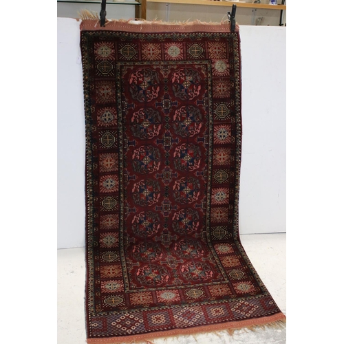 834 - Dark Red Ground Wool Rug with Geometric Pattern to centre surrounded by a border of square panels, 1... 