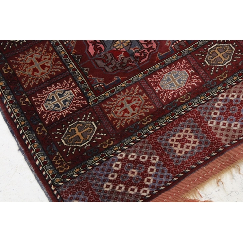 834 - Dark Red Ground Wool Rug with Geometric Pattern to centre surrounded by a border of square panels, 1... 