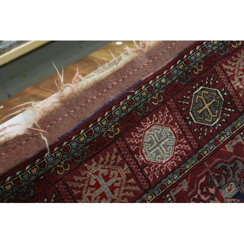 834 - Dark Red Ground Wool Rug with Geometric Pattern to centre surrounded by a border of square panels, 1... 