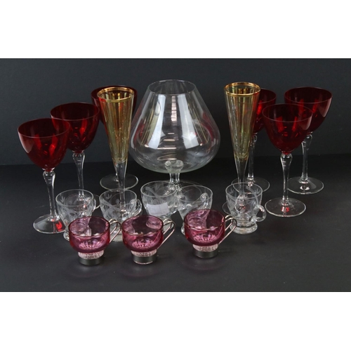 673 - A box of mixed glass ware to include cranberry glass custard cups, champagne flutes and brandy glass... 