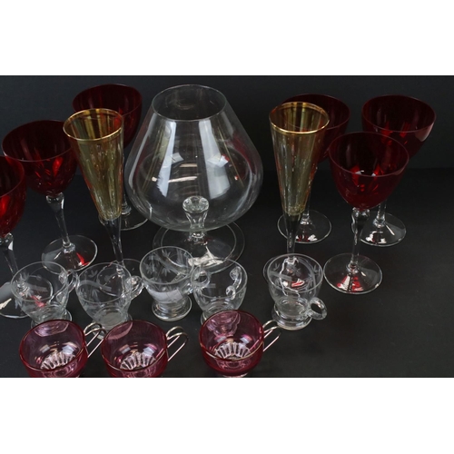 673 - A box of mixed glass ware to include cranberry glass custard cups, champagne flutes and brandy glass... 