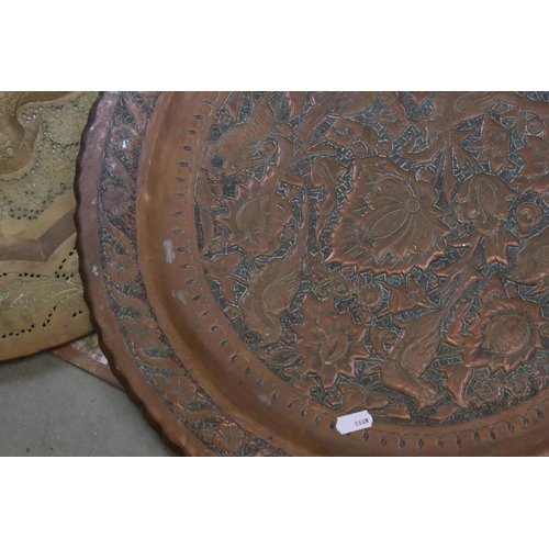 687 - A very large brass charger with stylized floral decoration 91 cm diameter together with two others s... 