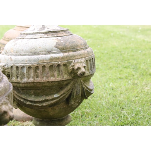 691 - A group of five stone urn shaped lion wall finials. measuring approx 46cm in height. (understood to ... 