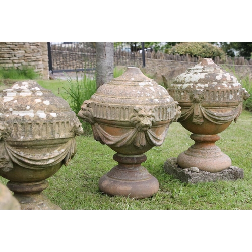 691 - A group of five stone urn shaped lion wall finials. measuring approx 46cm in height. (understood to ... 