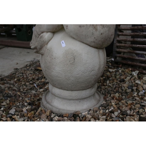 695 - A reconstituted stone wall finial with seated child to top, stands approx 64cm tall