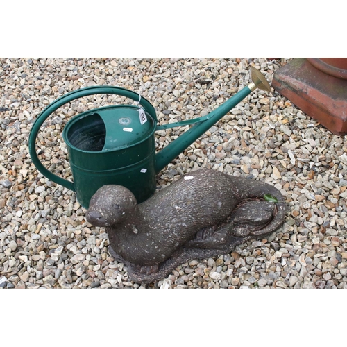 698 - A green metal watering can together with a stone Otter garden ornament.