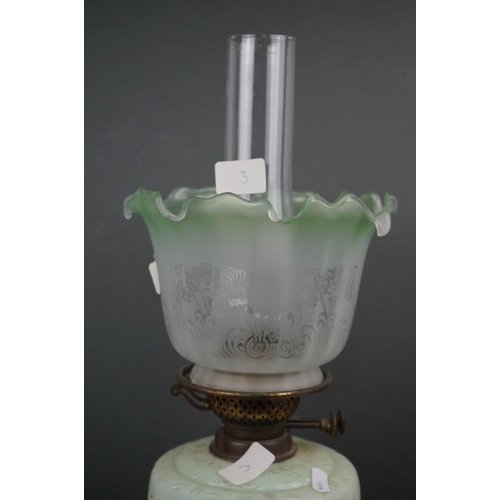 639 - An antique early 20th century oil lamp with pierced metal base, light green well & shade with floral... 