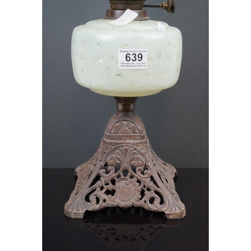 639 - An antique early 20th century oil lamp with pierced metal base, light green well & shade with floral... 