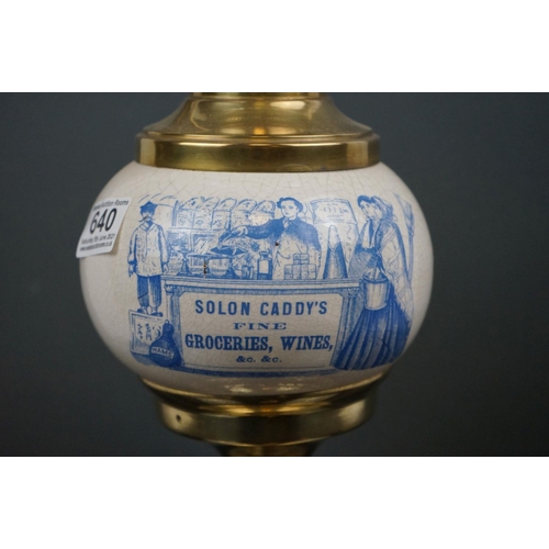 640 - An Edwardian brass oil lamp with advertising, Solon Caddy's Fine Groceries, with blue scrolling shad... 