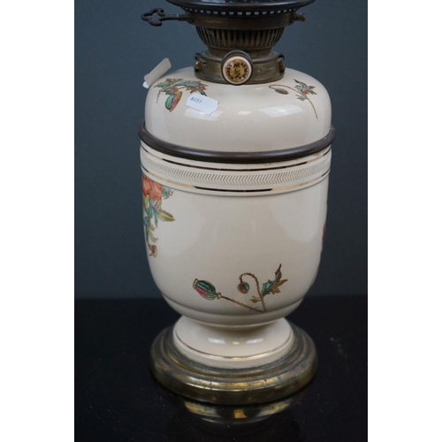 642 - A 20th century porcelain oil lamp with floral decoration and blue twisted scallop topped shade.