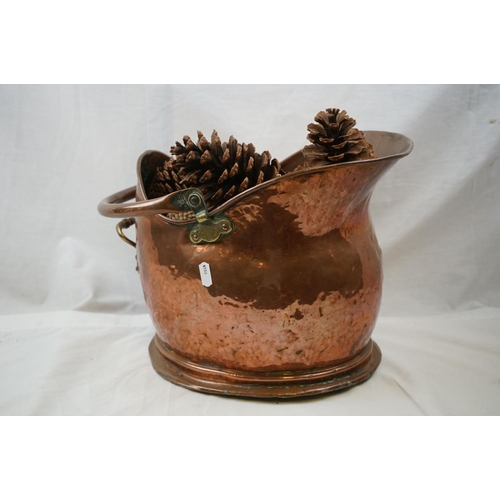 663 - An antique helmet copper coal bucket together with a table lamp.