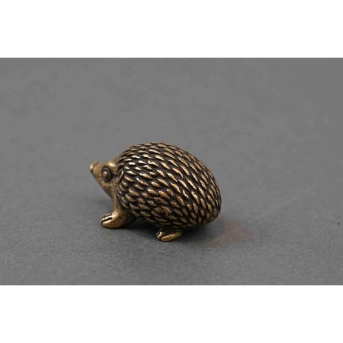 324 - A small brass figure of a hedgehog.