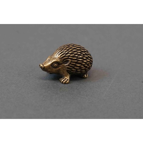 324 - A small brass figure of a hedgehog.