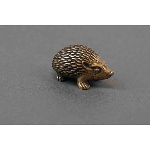 324 - A small brass figure of a hedgehog.