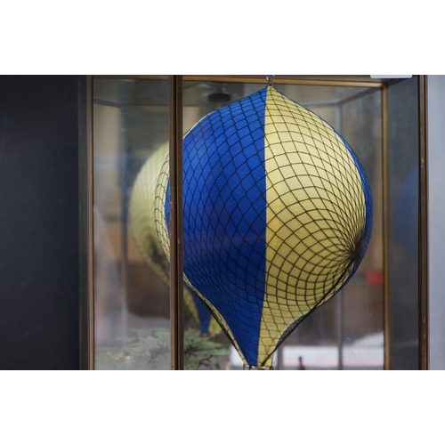 262 - A glass cased diorama titled 'Balloon Rides' with a display of painted metal figures and a suspended... 