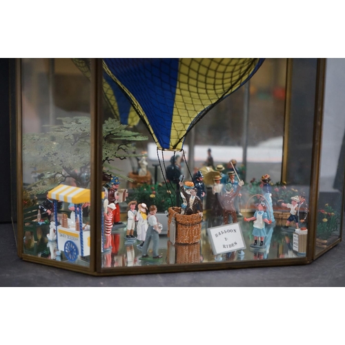 262 - A glass cased diorama titled 'Balloon Rides' with a display of painted metal figures and a suspended... 