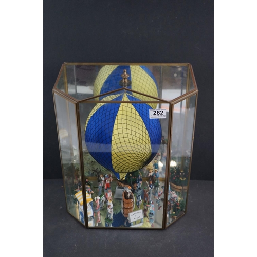 262 - A glass cased diorama titled 'Balloon Rides' with a display of painted metal figures and a suspended... 