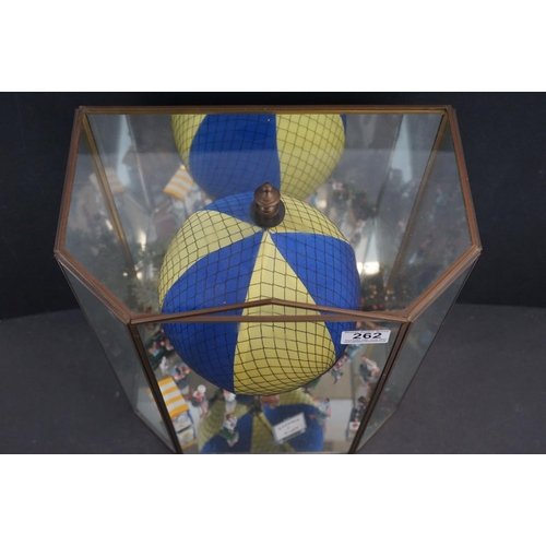 262 - A glass cased diorama titled 'Balloon Rides' with a display of painted metal figures and a suspended... 