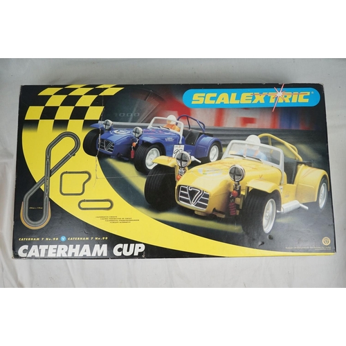 1090 - Boxed Scalextric Caterham Cup, appearing complete with two slot cars but unchecked (tatty box), plus... 