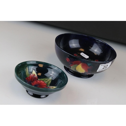 22 - A blue ground Moorcroft bowl with leaf and berry decoration af and a similar green ground bowl with ... 
