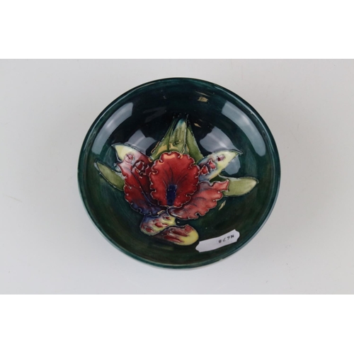22 - A blue ground Moorcroft bowl with leaf and berry decoration af and a similar green ground bowl with ... 