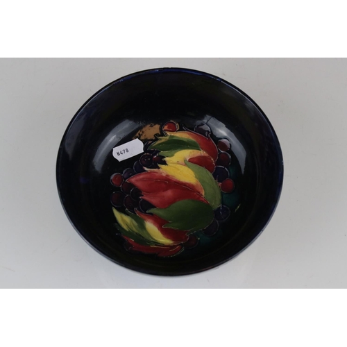 22 - A blue ground Moorcroft bowl with leaf and berry decoration af and a similar green ground bowl with ... 