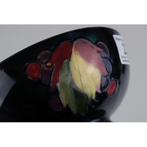22 - A blue ground Moorcroft bowl with leaf and berry decoration af and a similar green ground bowl with ... 